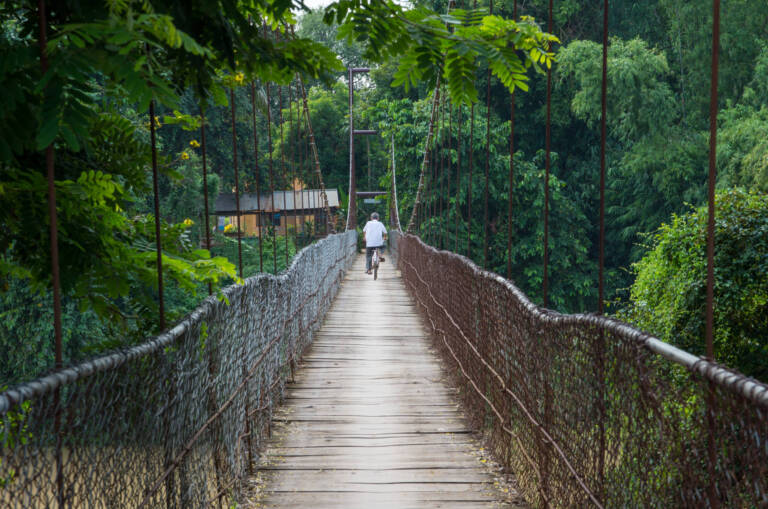viaggio in laos cambogia e vietnam Man riding bicycle crosses the bridge in Battambang