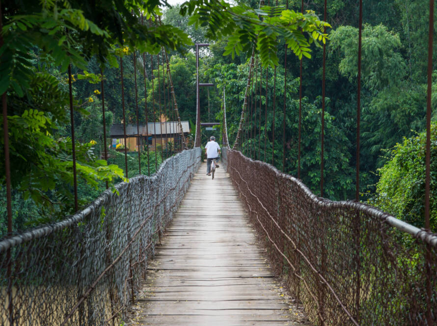 viaggio in laos cambogia e vietnam Man riding bicycle crosses the bridge in Battambang